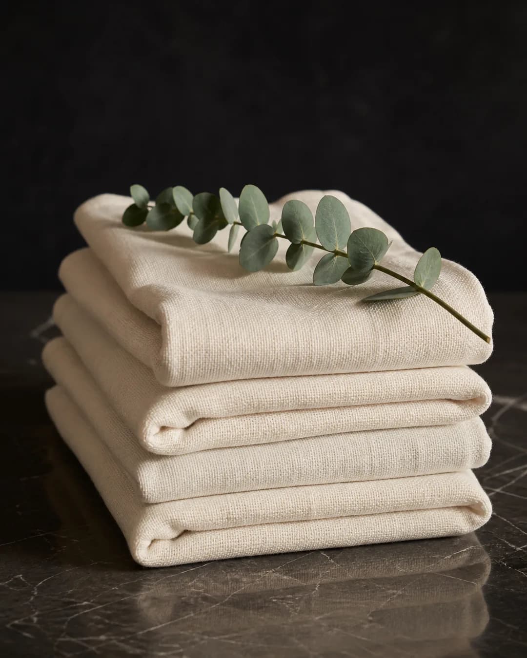Prosoape împăturite îngrijit, alături de frunze de eucalipt